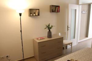 una stanza con cassettiera, lampada e cassettiera con una pianta di Casa Smeraldo a San Giovanni Lupatoto