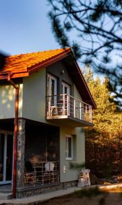 ein Haus mit einem Balkon mit zwei Stühlen darauf in der Unterkunft Vila Mishela in Berovo