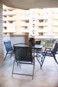 a patio with a table and chairs on a balcony at Beachfront Family Retreat, Marina d'Or in Oropesa del Mar