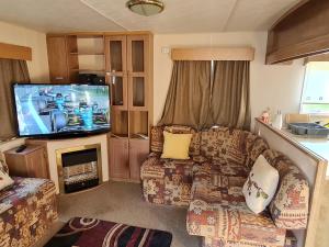 a living room with a couch and a flat screen tv at BLUE BIRD HOLIDAY HOME in Durham