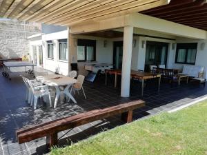 eine Terrasse mit Tischen und Stühlen und einem Dach in der Unterkunft VillaTerreno Casa Rural en Logroño in Villamediana de Iregua