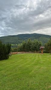 a large grass field with a gazebo in the middle at Wichrowe Wzgórze 4 in Rajcza