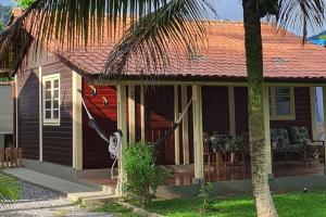 een klein huis met een palmboom ervoor bij Chalé super aconchegante em condomínio com garagem in São Sebastião