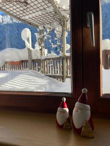 deux pingouins jouets se tiennent devant une fenêtre dans l'établissement Ferienwohnung Jägerheim, à Bürserberg