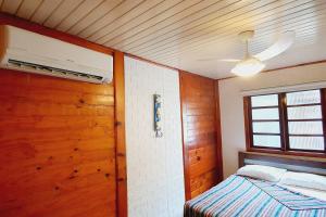 een slaapkamer met een bed en een houten plafond bij Chalé super aconchegante em condomínio com garagem in São Sebastião