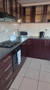 y cocina con fogones y microondas. en Mossie Inn Accommodation en Swakopmund