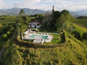 an aerial view of a house in a field with a swimming pool at Finca Maratón Alto in Calarcá