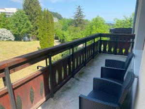 two chairs on a balcony with a view of a field at Vila Bellestay in Braşov