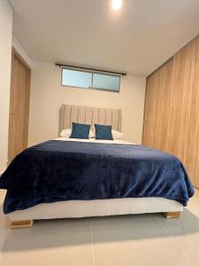 1 dormitorio con 1 cama grande con sábanas azules en Cartagena 3 habitaciones 9 personas cerca a la playa Wifi y Parqueadero, en Cartagena de Indias