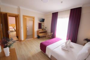 a hotel room with a bed and a window at Siriusmi Hotel in Çeşme