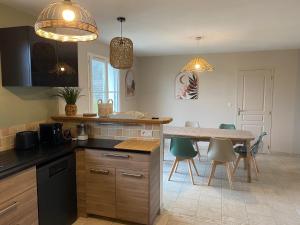 a kitchen with a counter and a table with chairs at Le Chant des étoiles in La Croix-en-Touraine