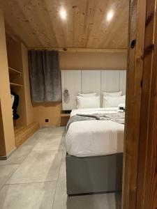 a bedroom with a large bed with a wooden ceiling at Les Secrets de in Montriond