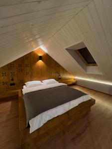 a bedroom with a large bed in an attic at Котедж Stodola Slavsko in Slavske