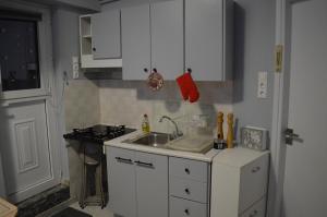 a kitchen with white cabinets and a sink and a stove at Loft at Sokratous in Athens