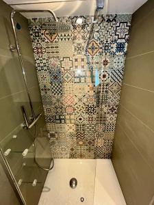 a bathroom with a shower with a tiled wall at Gorgeous Mini-Chalet Chamonix in Chamonix-Mont-Blanc
