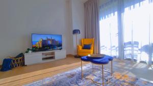 a living room with a television and a yellow chair at VIEVV Property Rentals in Dubai