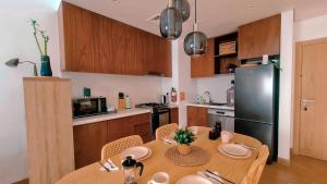 杜拜的住宿－VIEVV Property Rentals，厨房配有木桌和黑冰箱。