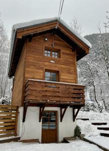 Gorgeous Mini-Chalet Chamonix في شامونيه مون بلان: كابينة خشب في الثلج مع باب