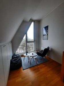een woonkamer met een tafel en een stoel bij Aprtman Divčigora C14 in Divčibare