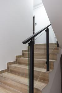a staircase with a black rail and wood floors at Glečer Kop, Cozy design apartment A5 in Kopaonik