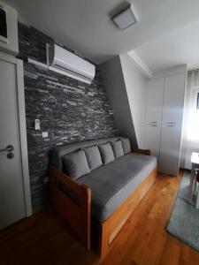 een slaapkamer met een bed en een bakstenen muur bij Aprtman Divčigora C14 in Divčibare