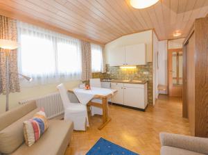 een keuken en een woonkamer met een tafel en een bank bij Landhaus Tritscher in Schladming
