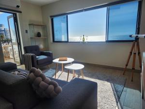 a living room with a couch and a table at Sunset Retreat at Bay Point in Cape Town