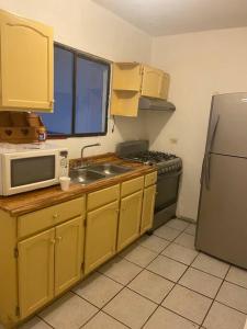 una cucina con lavello, forno a microonde e frigorifero di Hermoso condominio en Cd. Juárez, Chih. Céntrico a Ciudad Juárez