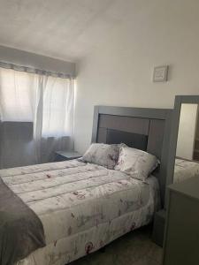 una camera da letto con un grande letto e un piumone bianco di Hermoso condominio en Cd. Juárez, Chih. Céntrico a Ciudad Juárez