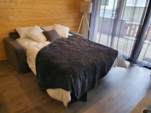 - une chambre avec un lit et une couverture noire dans l'établissement Magnifique appt NEUF 6 pers - vue montagne St Lary - curistes ok, à Vielle-Aure