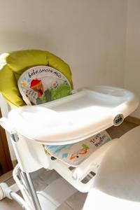 a high chair with a baby seat on it at Secret Paradise & SPA Rooftop in Quartu SantʼElena
