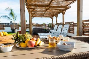 una mesa con platos de fruta en el patio en Secret Paradise & SPA Rooftop, en Quartu SantʼElena