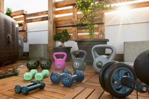 a group of dumbbells on a wooden floor at Secret Paradise & SPA Rooftop in Quartu SantʼElena
