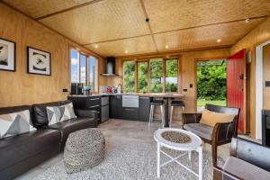 a living room and kitchen in a tiny house at Kūkū Kabin - Waimate North Eco Holiday Cabin in Kerikeri