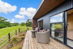 a wooden deck with chairs on a house at Kūkū Kabin - Waimate North Eco Holiday Cabin in Kerikeri