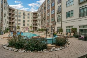 an apartment complex with a pool in front of a building at Corporate Modern Apt , Pool, Gym, Parking Cs in Dallas