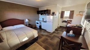Habitación de hotel con cama y cocina en Caravel Motel en Swift Current