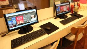 a desk with two computer monitors and a keyboard and mouse at Hotel Skypark Myeongdong 3 in Seoul