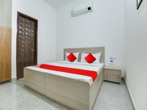 1 dormitorio con 1 cama grande con almohadas rojas en OYO Hotel Classic in, en Mohali