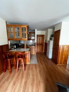 a kitchen with wooden cabinets and a table and chairs at Departamento con vista al volcán en Pucón in Pucón