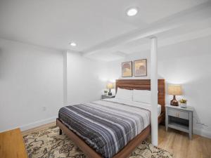 a white bedroom with a bed and two tables and two lamps at Shadyside, Pittsburgh, Modern and Quiet 1 Bedroom Unit1 with Free Parking in Pittsburgh
