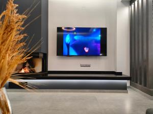a living room with a tv on a wall at Meteora Scenic Loft in Kalabaka