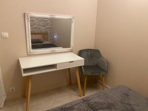 AJ Apartment 2, Santa Marina Holiday Village, Sozopol في سوزوبول: غرفة نوم مع مكتب مع مرآة وكرسي