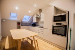 a small kitchen with a table and a microwave at Luxury Fulham 3 bedroom Garden House in London