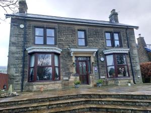 a brick house with black windows and a door at Thorndene B&B in Hope