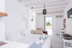 ein weißes Zimmer mit 2 Betten und einem Sofa in der Unterkunft Cycladic Islands Hotel & Spa in Agia Anna