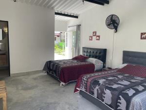 a bedroom with two beds and a clock on the wall at Blue River in Santa Marta