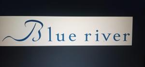 a white sign with the word the river at Blue River in Santa Marta