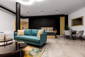 Warowna 2 Premium Spa Jacuzzi & Sauna في بيشتنا: غرفة معيشة مع أريكة زرقاء وغرفة نوم