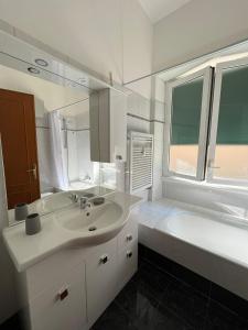 uma casa de banho branca com um lavatório e uma banheira em Appartamento Vacanze Romane em Roma